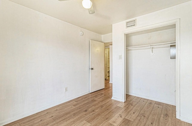 unfurnished bedroom featuring ceiling fan, light hardwood / wood-style floors, and a closet