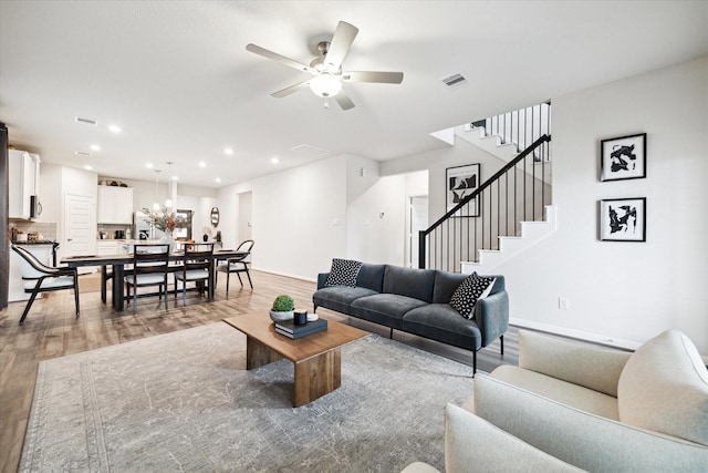 living room featuring ceiling fan and light hardwood / wood-style flooring