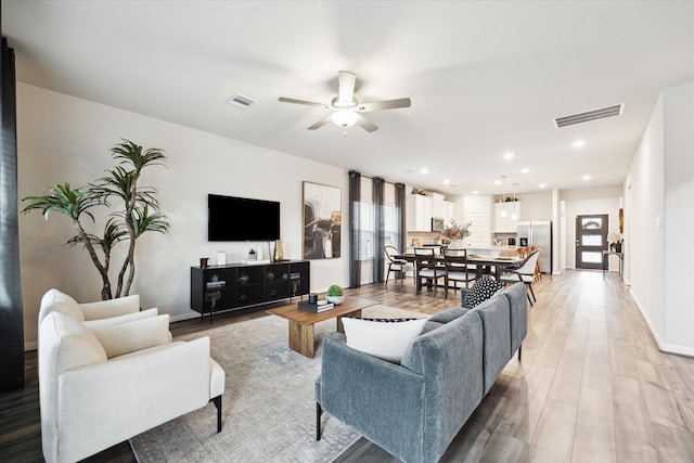 living room featuring light hardwood / wood-style flooring and ceiling fan