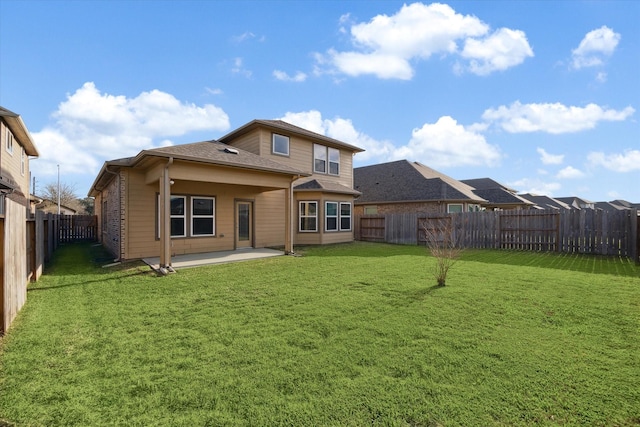 rear view of house with a yard and a patio