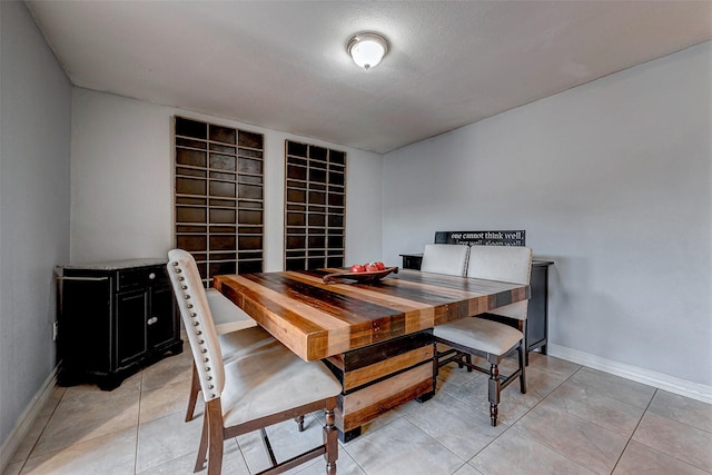 dining area featuring light tile patterned flooring and baseboards