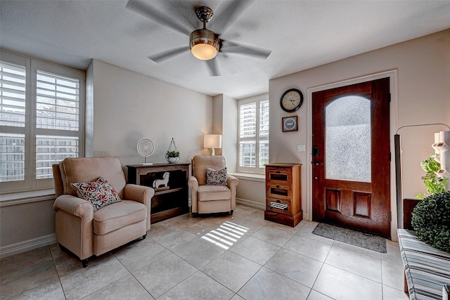 entryway with ceiling fan, baseboards, and light tile patterned flooring