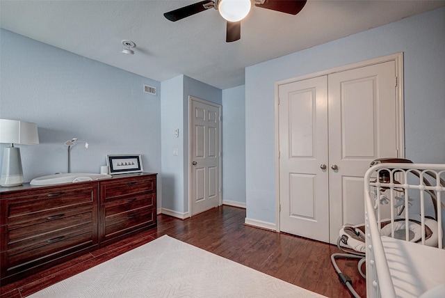 bedroom featuring baseboards, a closet, visible vents, and wood finished floors