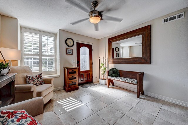 entryway featuring baseboards, visible vents, a ceiling fan, and light tile patterned flooring