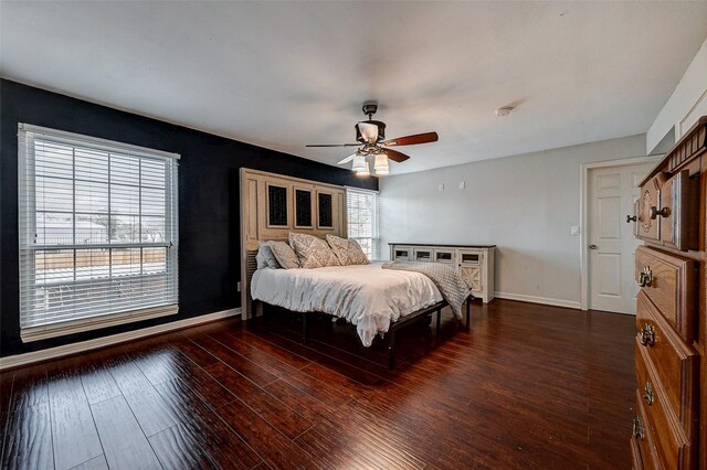 bedroom featuring wood finished floors, a ceiling fan, and baseboards