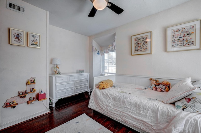 bedroom with ceiling fan, visible vents, and dark wood-type flooring