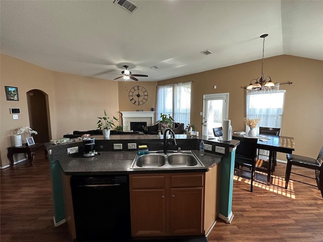 kitchen featuring dishwasher, sink, a center island with sink, and decorative light fixtures