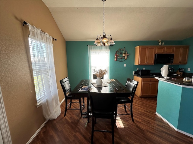 dining space featuring vaulted ceiling, dark wood-type flooring, and an inviting chandelier