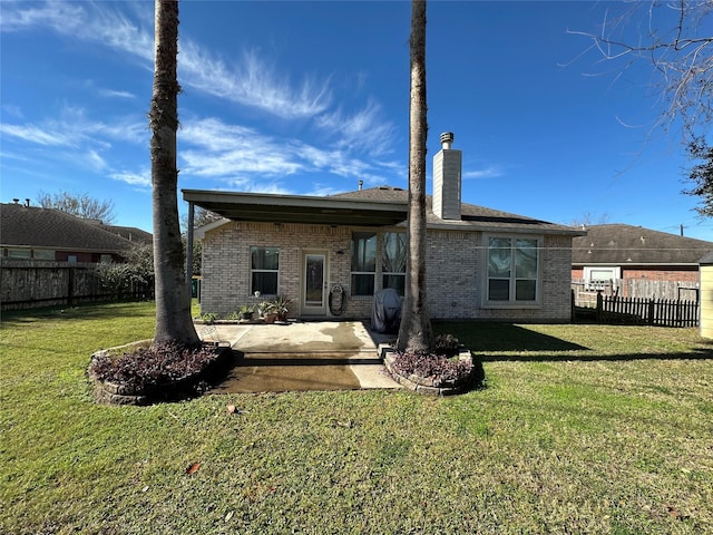 rear view of house with a yard and a patio area