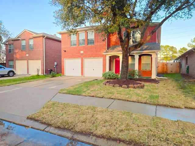 traditional-style house featuring brick siding, a front yard, fence, a garage, and driveway