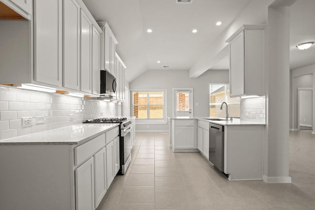 kitchen featuring sink, white cabinetry, light tile patterned floors, appliances with stainless steel finishes, and light stone countertops