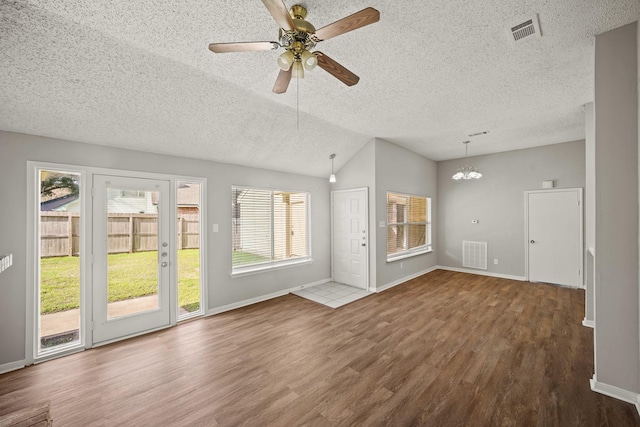 unfurnished living room with visible vents, vaulted ceiling, a textured ceiling, and wood finished floors