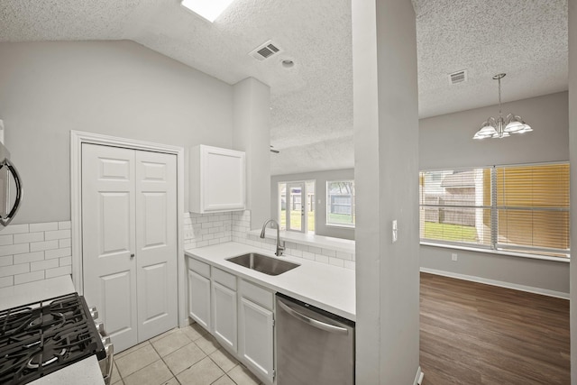 kitchen featuring stainless steel appliances, a sink, visible vents, white cabinets, and light countertops