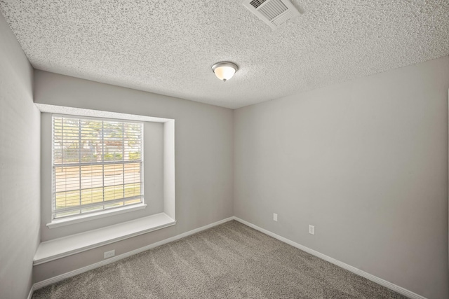 carpeted spare room featuring visible vents, a textured ceiling, and baseboards