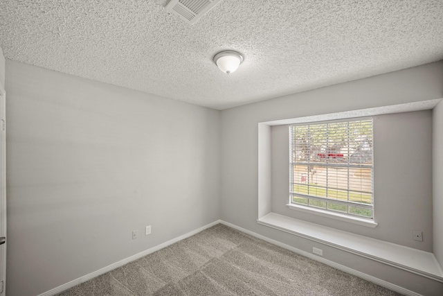 unfurnished room with baseboards, visible vents, a textured ceiling, and carpet flooring