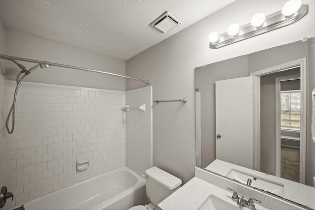 full bath featuring a textured ceiling, toilet, vanity, visible vents, and washtub / shower combination