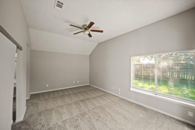 additional living space with carpet, visible vents, vaulted ceiling, ceiling fan, and baseboards