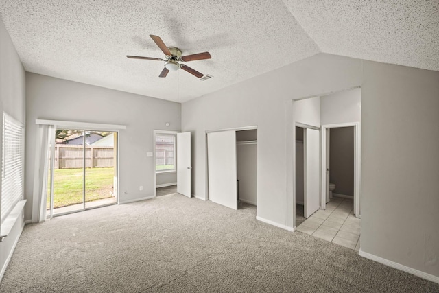 unfurnished bedroom with lofted ceiling, ceiling fan, access to exterior, a textured ceiling, and carpet floors