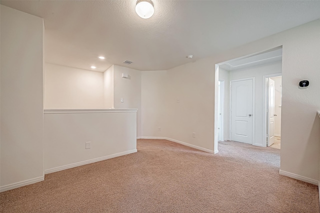 empty room featuring baseboards, recessed lighting, and light colored carpet