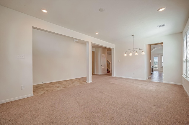 empty room featuring visible vents, baseboards, light colored carpet, stairs, and recessed lighting