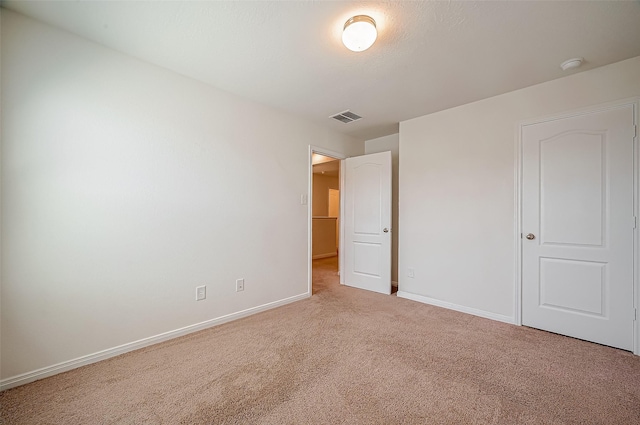 unfurnished bedroom featuring carpet floors, visible vents, and baseboards