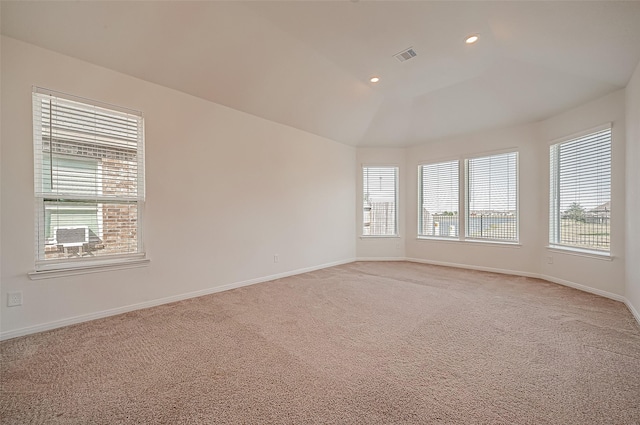 spare room featuring lofted ceiling, recessed lighting, light colored carpet, visible vents, and baseboards