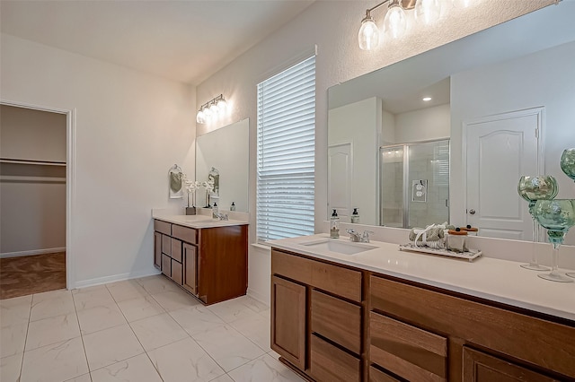 bathroom with marble finish floor, two vanities, a sink, and a shower stall