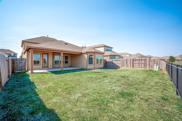 back of house featuring a yard, a fenced backyard, and a patio