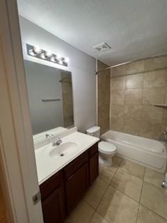 full bathroom with tile patterned flooring, vanity, tiled shower / bath combo, and toilet