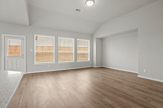 spare room featuring lofted ceiling and wood-type flooring