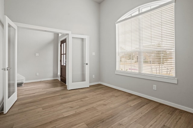 unfurnished room featuring light hardwood / wood-style flooring and french doors