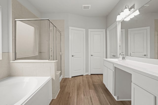 bathroom featuring vanity, wood-type flooring, and separate shower and tub