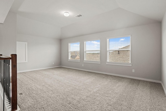 empty room with vaulted ceiling and carpet