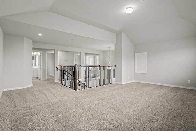 unfurnished room featuring carpet floors and vaulted ceiling