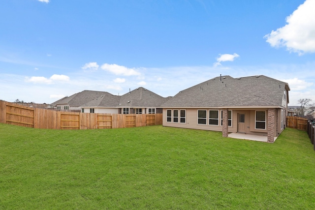 rear view of house with a yard and a patio area