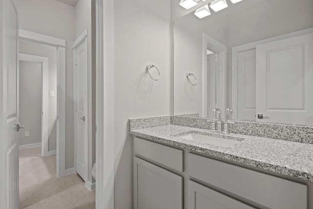 bathroom with tile patterned flooring, vanity, and toilet