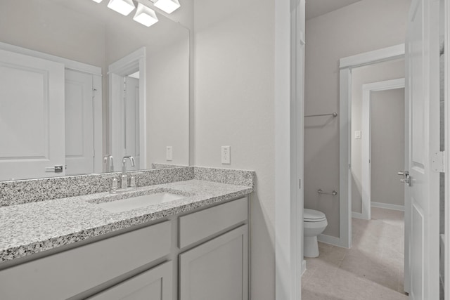 bathroom featuring vanity, tile patterned floors, and toilet