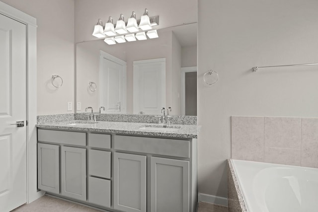 bathroom featuring tile patterned floors, vanity, and tiled tub