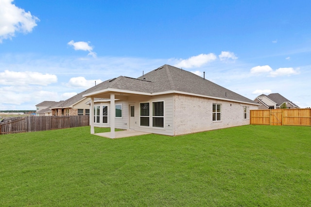 rear view of house with a yard and a patio area