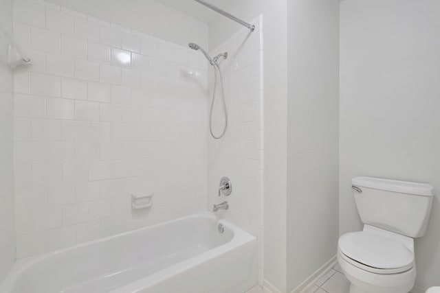 bathroom featuring toilet, tiled shower / bath combo, and tile patterned flooring