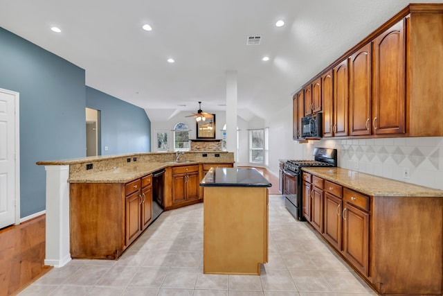 kitchen featuring lofted ceiling, sink, black appliances, a kitchen island, and kitchen peninsula