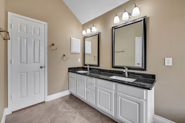 bathroom with tile patterned flooring, vaulted ceiling, and vanity