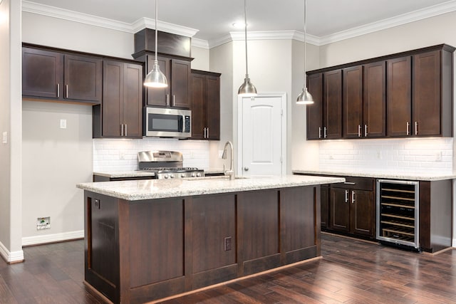 kitchen with stove, pendant lighting, light stone countertops, and beverage cooler