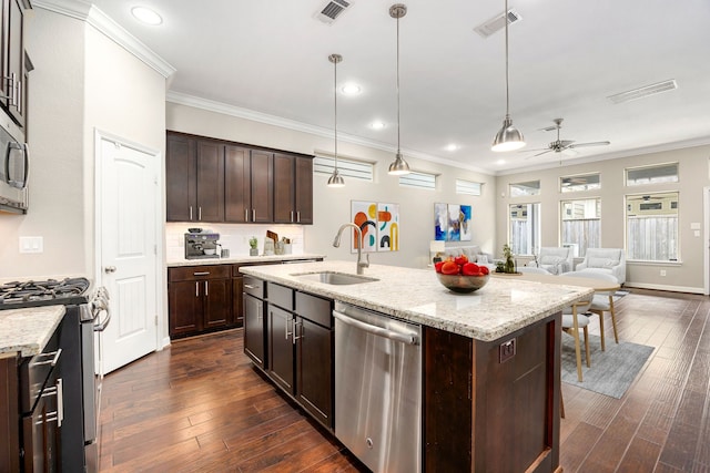 kitchen featuring sink, appliances with stainless steel finishes, dark brown cabinetry, an island with sink, and decorative light fixtures