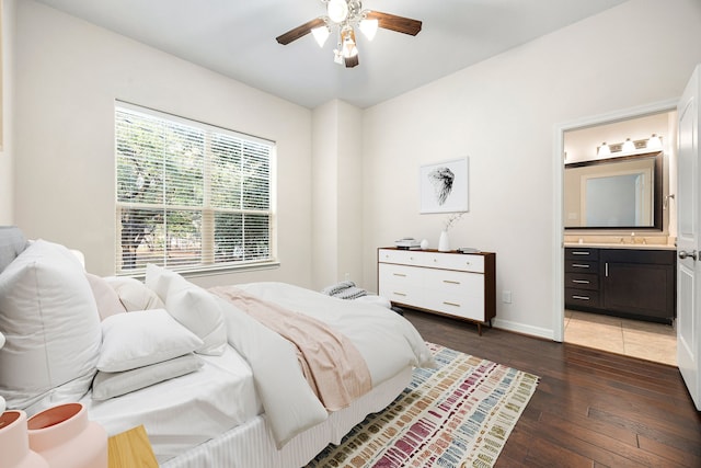 bedroom featuring ceiling fan, dark wood-type flooring, and ensuite bath