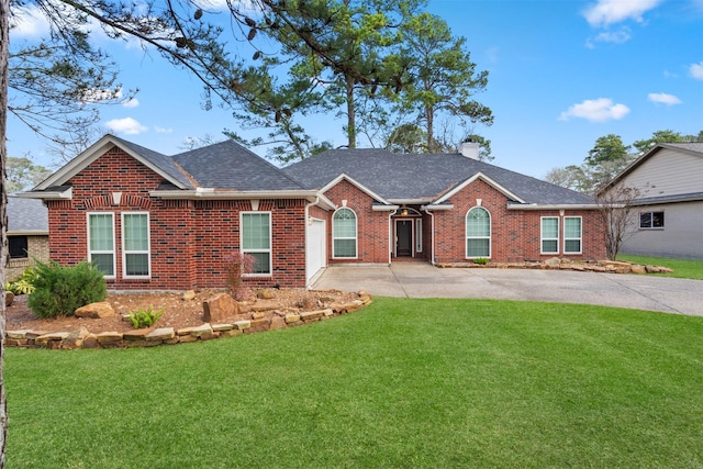 ranch-style home featuring brick siding, driveway, a chimney, and a front lawn