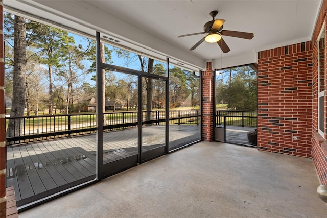 unfurnished sunroom with a ceiling fan