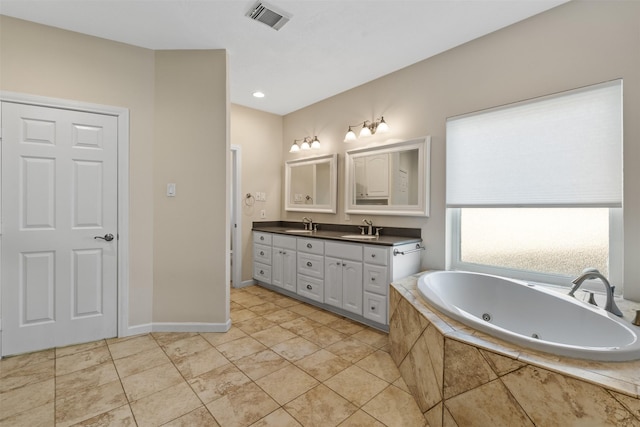 full bathroom featuring double vanity, visible vents, a tub with jets, tile patterned flooring, and a sink