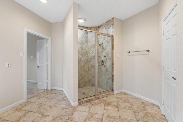 bathroom featuring a shower stall and baseboards