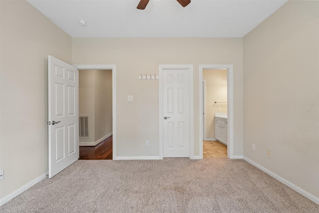 unfurnished bedroom with light carpet, baseboards, visible vents, and connected bathroom